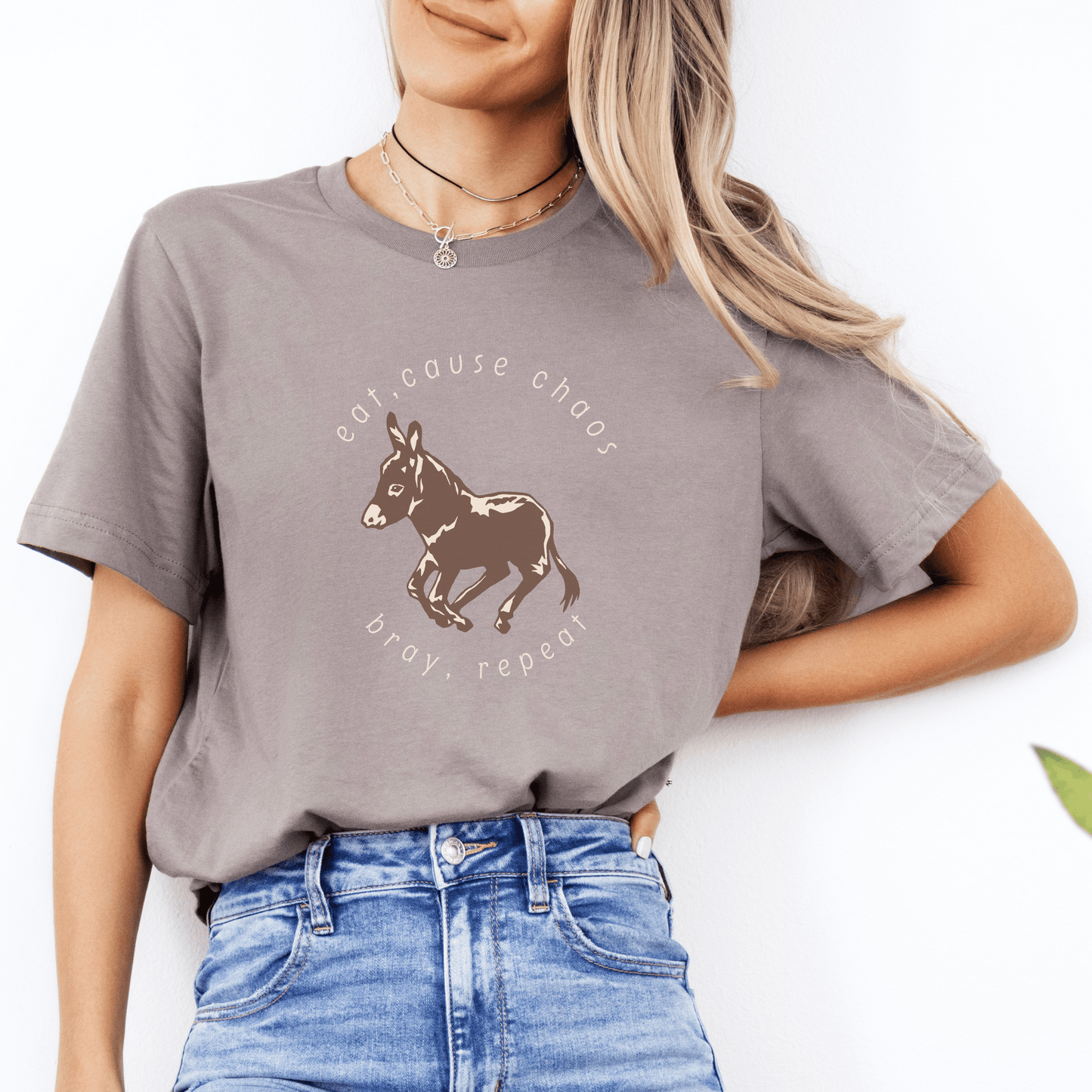 donkey t-shirt featuring a cute donkey design and the fun saying eat, cause chaos, bray, repeat. This whimsical and charming tee is perfect for donkey lovers