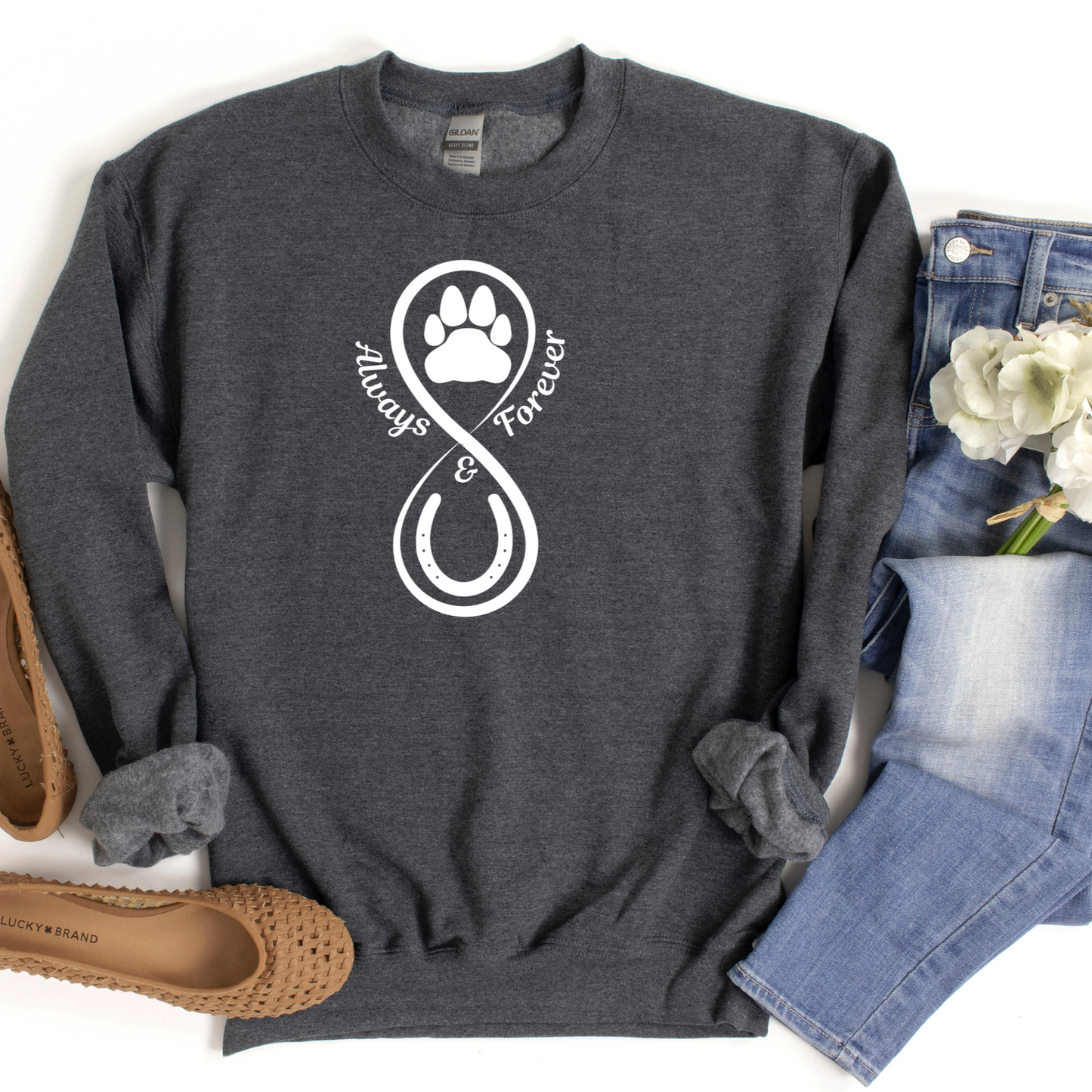 Our Always and Forever Pet Sweatshirt is a must-have for all pet parents! Featuring the words Always and Forever accompanied by an infinity symbol, horse shoe, and paw print, this shirt serves as a beautiful tribute to the treasured memories of your beloved pets.