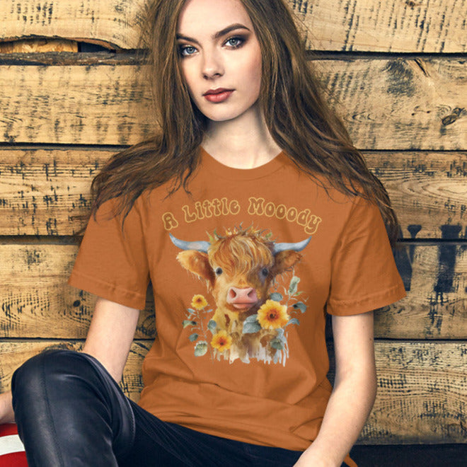 a little moody saying, perfectly complemented by an adorable Highland cow calf and a radiant arrangement of sunflowers on a t-shirt