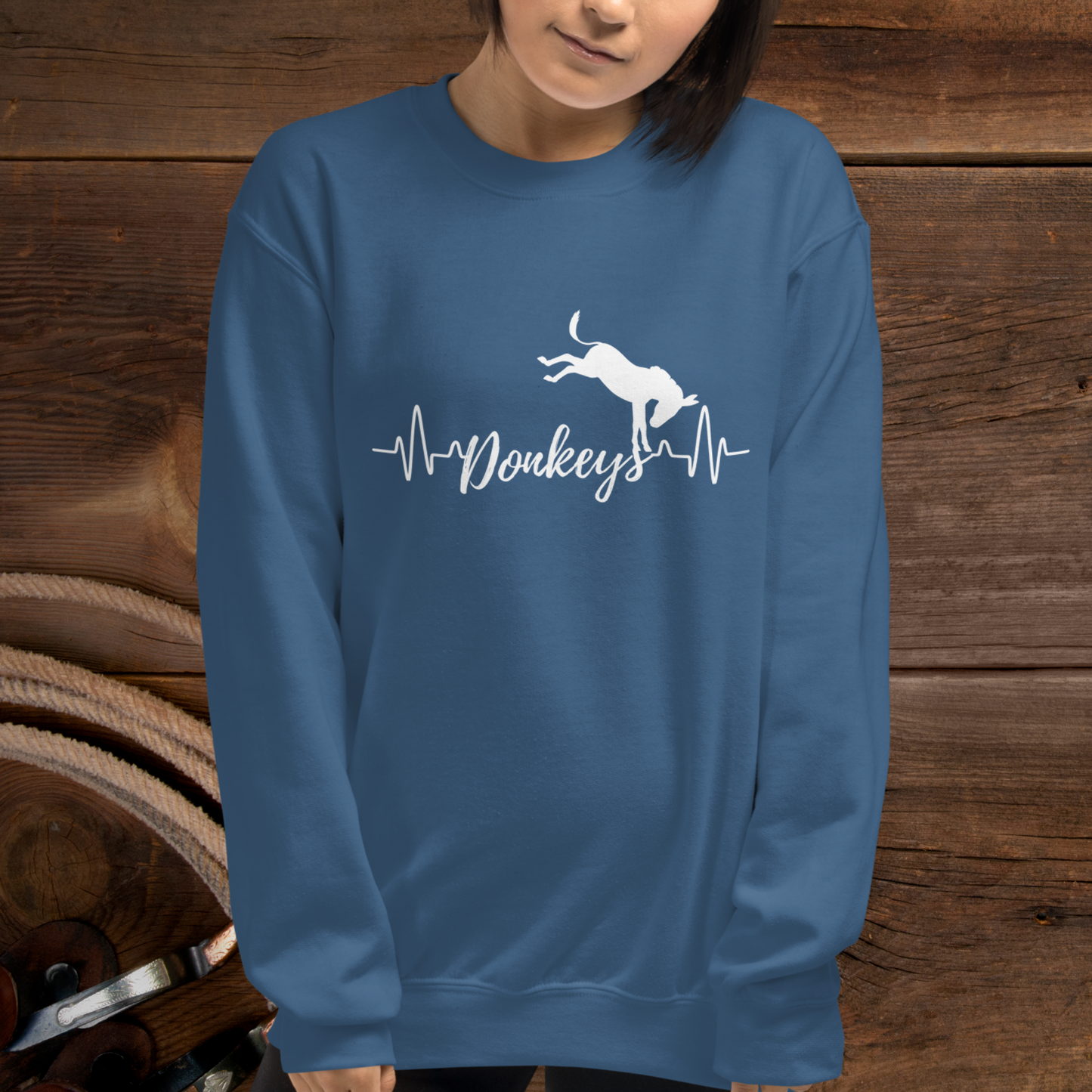 Indigo crew neck sweatshirt with a heart beat design with the word Donkeys in the middle of the heartbeat, with a silhouette of a bucking donkey above it.