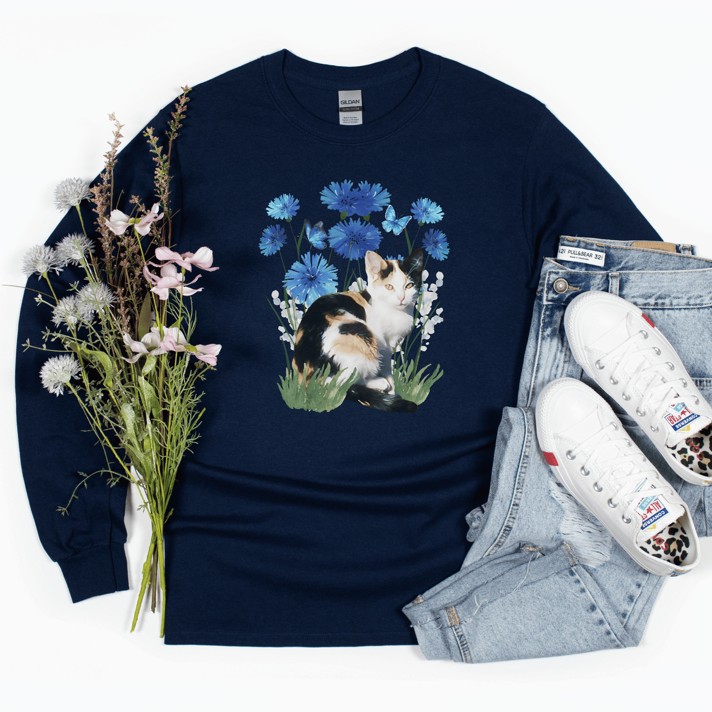 Featuring a delightful blue flower design and an adorable calico cat, this t-shirt is both stylish and comfortable. Made with high-quality materials,
