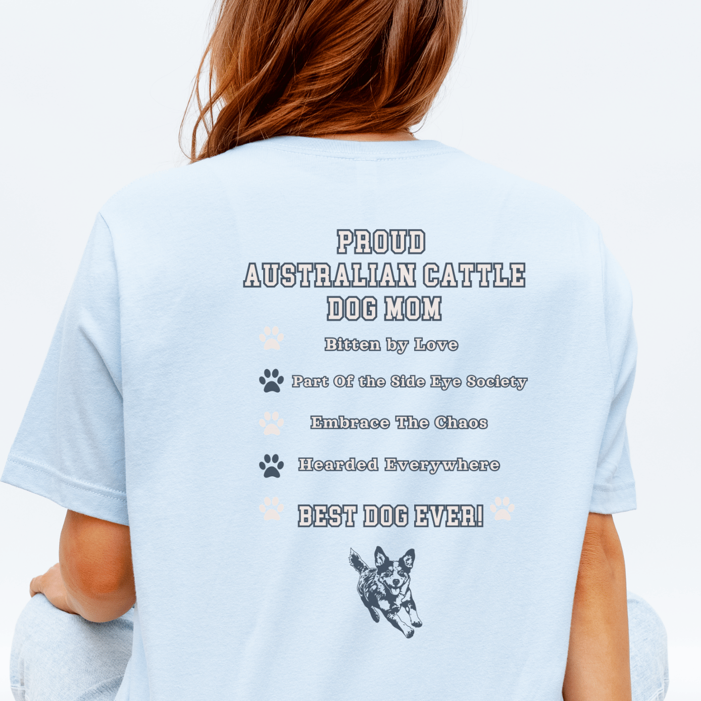 Person wearing a light blue t-shirt with text and a dog graphic on the back, sitting on a yellow and white checkered floor.