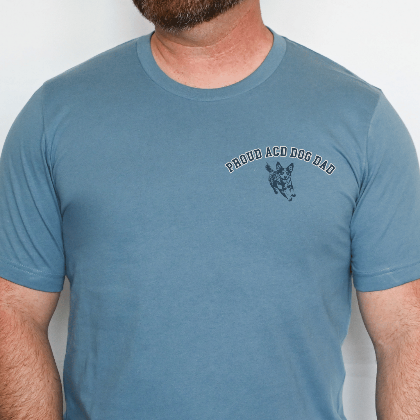 Man wearing a blue t-shirt with 'Proud ACO Dog Dad' text and graphic on a white background
