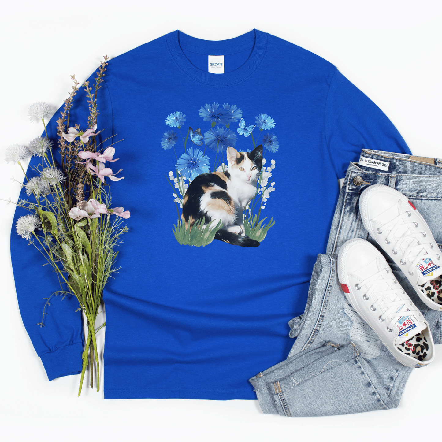 Featuring a delightful blue flower design and an adorable calico cat, this t-shirt is both stylish and comfortable. Made with high-quality materials,