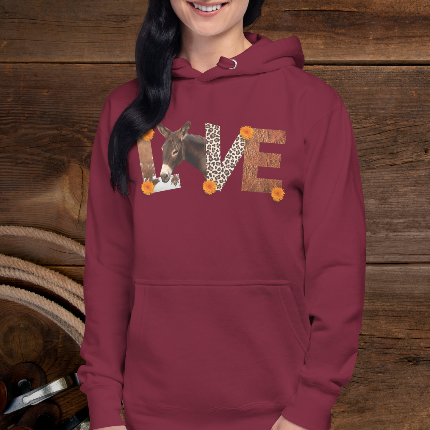 A Maroon pull over hoodie sweatshirt with has the word Love spelled out with cow hide as the L , a donkey as the O, Leopard print and the V and tooled leather as the E